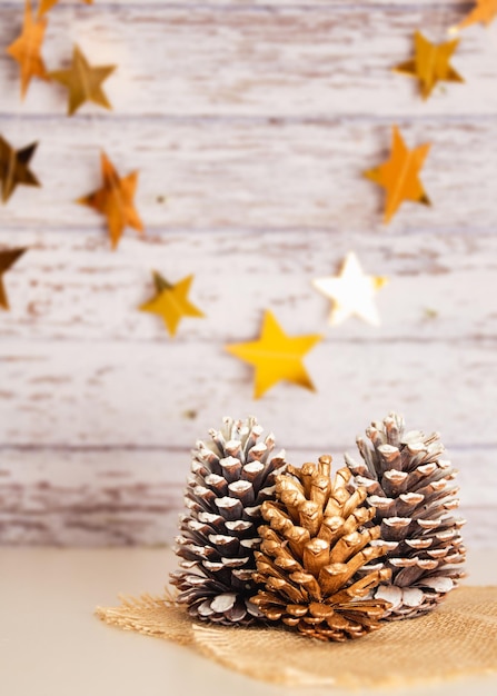 Noël, décoration du Nouvel An, pommes de pin, étoiles brillantes dorées, espace de copie de fond en bois clair