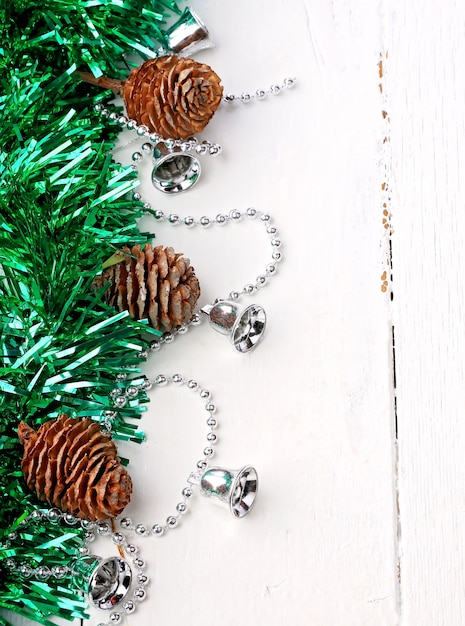 Noël une décoration de vacances sapin rustique vieux cônes clinquant hiver blanc en bois rétro vintage guirlande de cloches d'argent