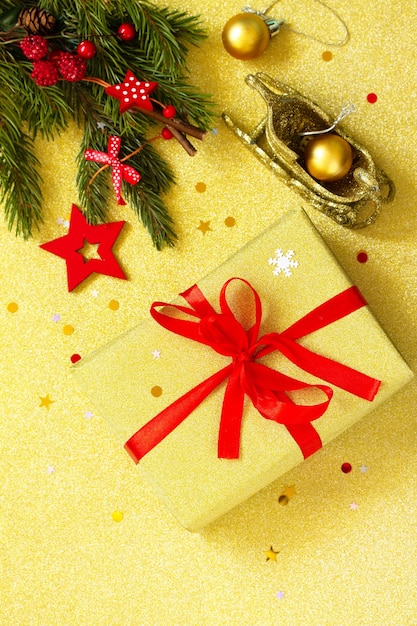 Noël fait à la main présente une boîte dorée avec un ruban rouge et un décor de branche d'arbre Vue de dessus Espace de copie