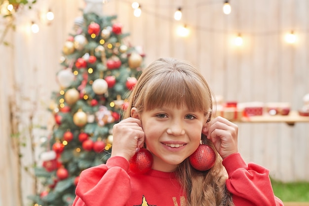 Noël en famille en juillet Portrait de jeune fille près de l'arbre de Noël avec des cadeaux