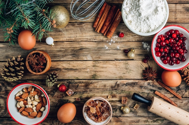 Noël - fond de gâteau de cuisson. Ingrédients de la pâte et décorations sur table en bois rustique