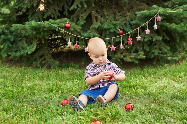 Noël en juillet, petit garçon à Noël. tir en été dans le parc, décor du nouvel an