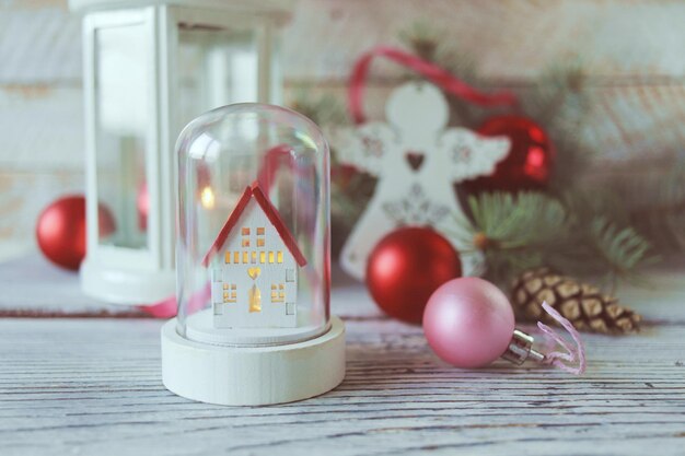 Noël, lanterne blanche avec une bougie allumée, anges jouets, sur un fond en bois