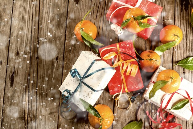 Noël et. Mandarines fraîches avec des feuilles vertes dans un panier blanc, décoration de Noël et coffrets cadeaux, sur une vieille table en bois rustique, vue de dessus effet neige tonique