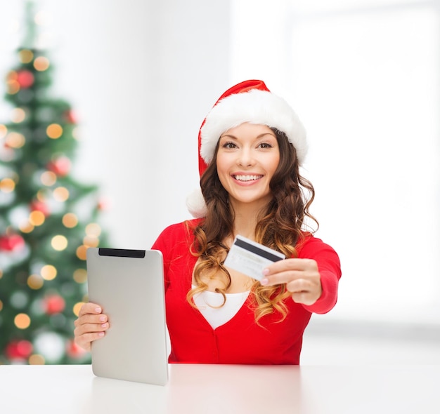 Noël, Noël, concept d'achat en ligne - femme en bonnet de noel avec boîte-cadeau, ordinateur tablette et carte de crédit