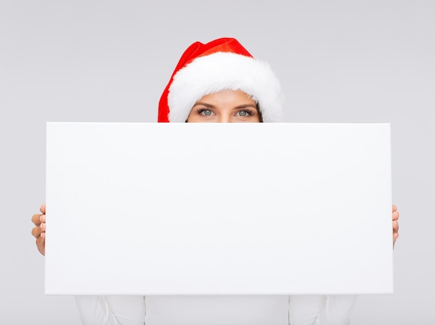 noël, noël, gens, hiver, publicité et concept de vente - femme surprise en bonnet de noel avec tableau blanc vierge