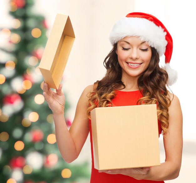 Noël, Noël, hiver, concept de bonheur - femme souriante en bonnet de Noel avec boîte-cadeau