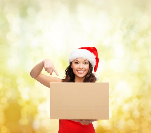 noël, noël, hiver, concept de bonheur - femme souriante en bonnet de noel avec boîte à colis