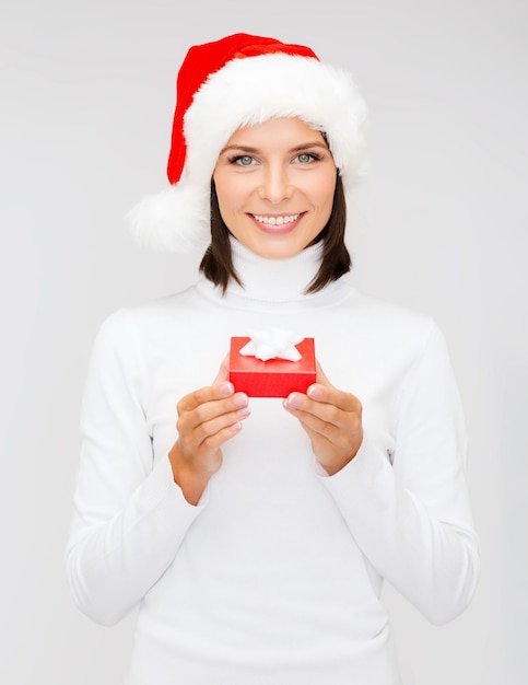 noël, noël, hiver, concept de bonheur - femme souriante en bonnet de noel avec petite boîte cadeau