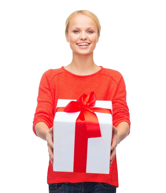 noël, noël, saint valentin, concept de célébration - femme souriante en pull rouge avec boîte-cadeau