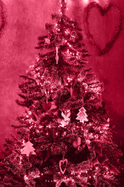 Noël et nouvel an arbre de noël décoré de jouets rétro vintage et de guirlandes de lumières rougeoyantes saison des vacances d'hiver à la maison dans les tons de couleur tendance viva magenta de l'année 2023