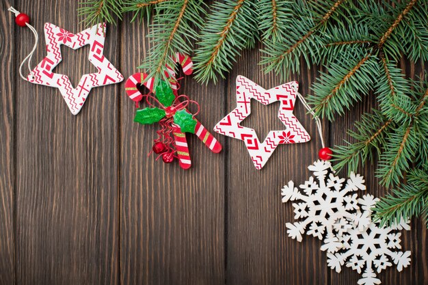 Noël Ou Nouvel An. Branches De Sapin, Jouets Pour Arbres De Noël, étoiles, Flocon De Neige Et Cônes Sur Bois Brun Foncé.