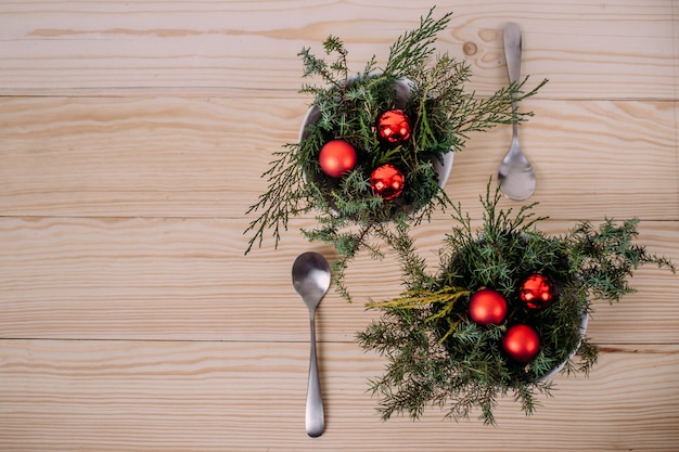 Noël et nouvel an dans un restaurant et un café. Dans une assiette sont des branches d'arbres de Noël et des boules de Noël. copyspace et mise à plat.