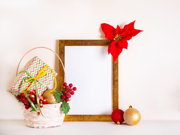 Noël, Nouvel An, panier à cadre avec des boules de jouet, des branches de sapin, des poinsettias et des baies pour la décoration, espace pour le texte, modèle de salutation des saisons