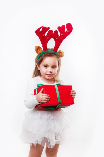 Noël petit bébé dans des cornes de cerf tenant une boîte cadeau rouge