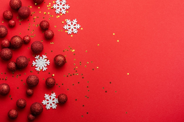 Noël plat poser avec sapin, avec arbre de Noël fait de boules de jouets rouges décorées de confettis dorés dans une enveloppe rouge sur rouge.