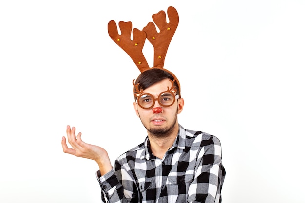 Noël, vacances et concept drôle - homme avec des cornes de cerf et rudolf nous sur mur blanc