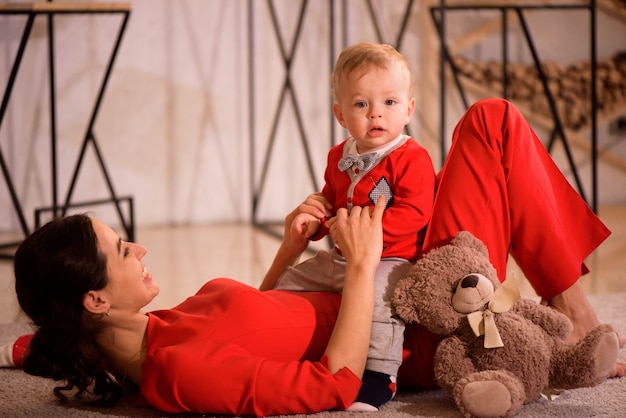 Noël, vacances, concept de famille - heureuse mère et enfant jouent à la maison.