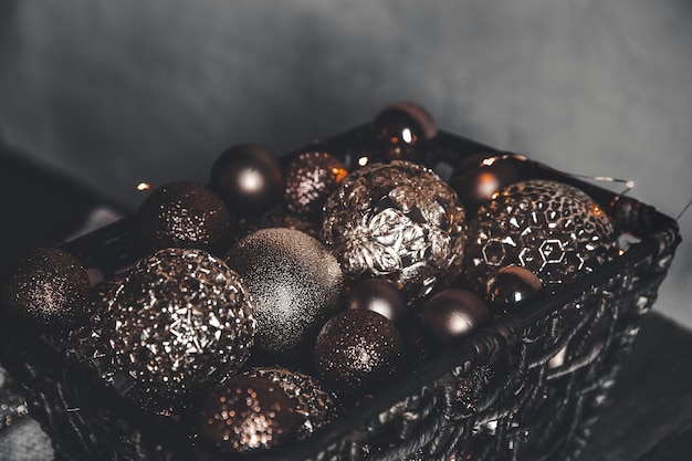 Noël vintage, jouets du nouvel an et décoration dans un panier sur une table en bois marron avec des guirlandes, espace pour copie