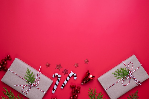 Noël vue de dessus de boîte de cadeau avec des branches d&#39;épinette, pommes de pin, baies rouges sur arr.plans rouge