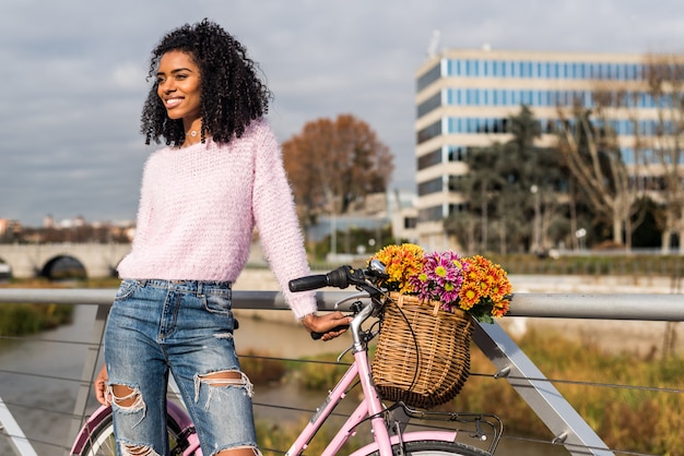 Noir jeune femme monté sur un vélo vintage