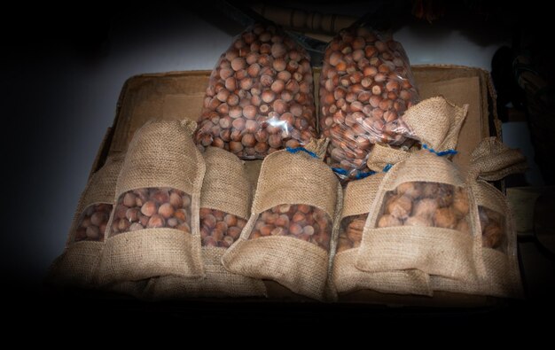 Photo noisettes mûres avec des coquilles dans de petits sacs comme fond alimentaire en vue