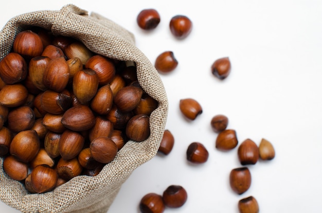 Noisettes, noisette dans un sac en toile de jute sur fond blanc .. tas ou pile de noisettes.