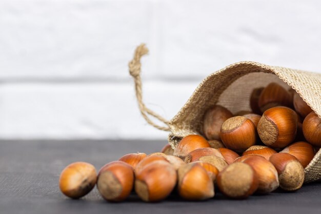 Noisettes, noisettes dans un sac de jute sur une table en bois rustique. tas ou pile de noisettes. Fond de noisette, nourriture saine