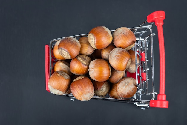 Noisettes nutritives dans un panier et dispersées sur le sol. Noisettes dans un panier. Orishki sain et diététique dans le panier. Arrière-plan avec place pour le texte