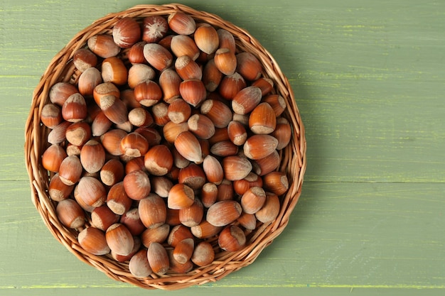 Noisettes sur tapis en osier sur fond de bois