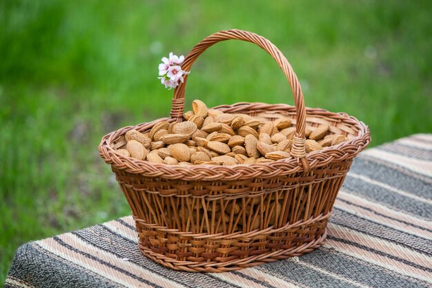 Des noix d'amande dans un panier sur un fond en bois