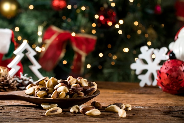 Noix brésiliennes: Castanha do Para dans un bol sur la planche avec fond de Noël flou