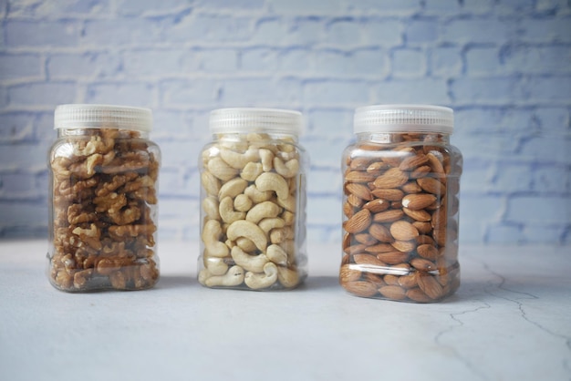 Noix de cajou et amandes de noix dans un récipient sur la table