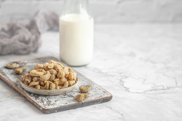 Noix de cajou crues sur table et bouteille de lait