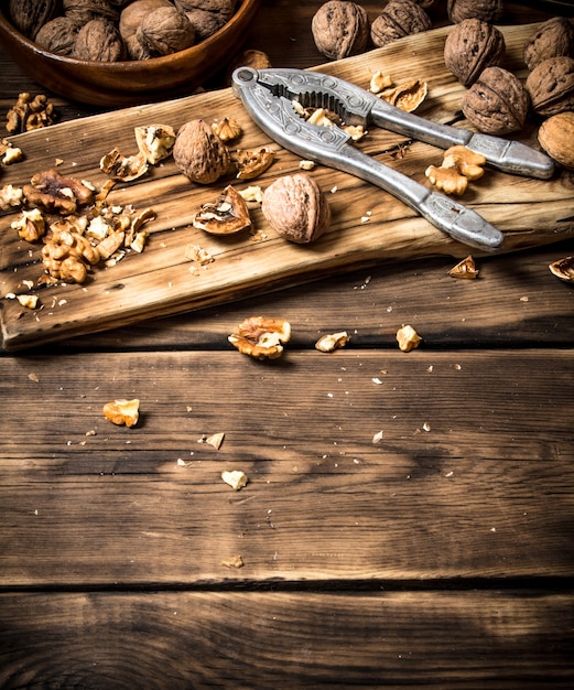 Noix avec casse-noisette sur la planche. Sur une table en bois.