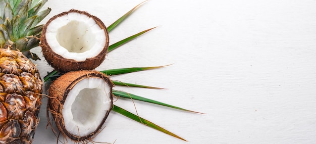 Noix de coco et ananas sur fond de bois Fruits tropicaux et noix Vue de dessus Espace libre pour le texte