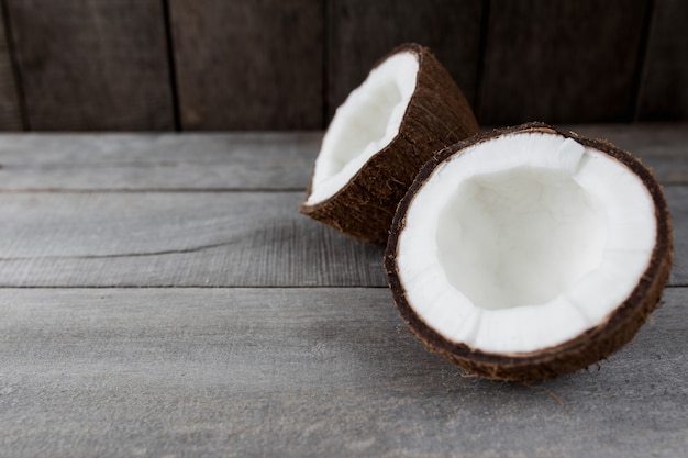 Noix de coco cassées sur fond de bois gris. Pulpe de noix de coco blanche. Photo de haute qualité