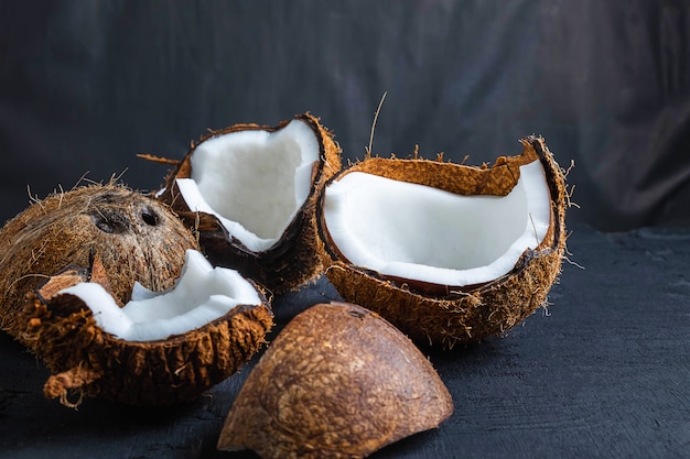 Noix de coco coupée en deux sur fond noir