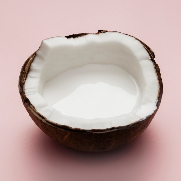 Photo noix de coco coupée en deux sur fond rose