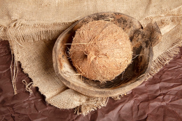 Noix de coco dans une vieille assiette en bois antique