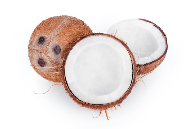Noix de coco entières et fêlées isolées sur fond blanc. Fruits de noix de coco décortiqués présentant les trois pores caractéristiques. Coupé en deux gros plan de noix de coco.
