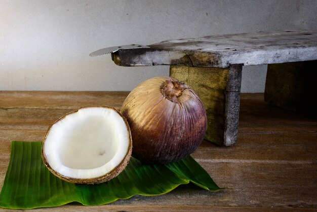 Noix de coco sur une feuille de bananier et une râpe à la noix de coco