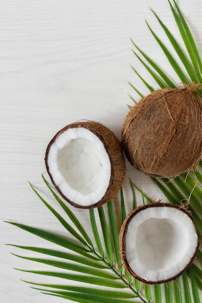 Noix de coco avec feuille de palmier sur fond de bois blanc Fruits tropicaux
