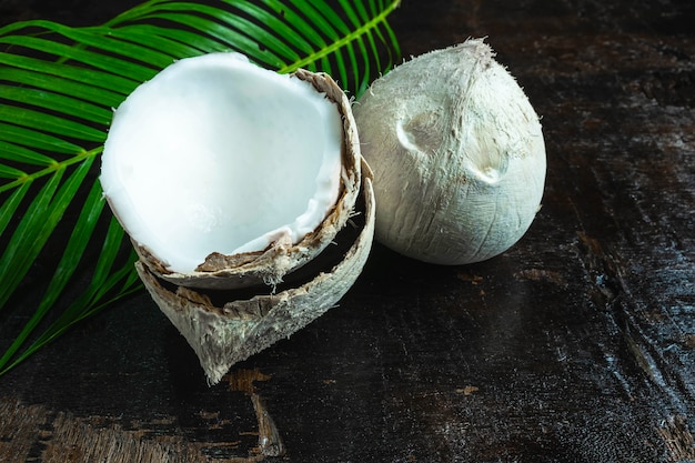 noix de coco avec des feuilles sur fond en bois