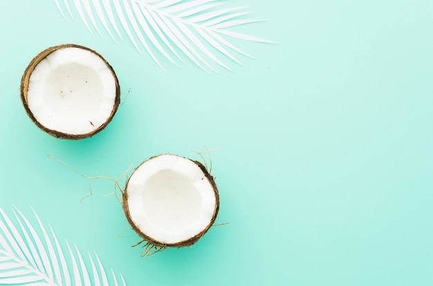 Photo noix de coco avec des feuilles de palmier sur la table