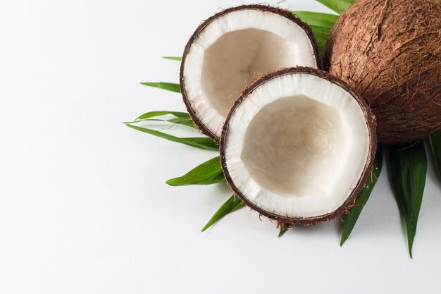 Noix de coco avec des feuilles vertes sur fond blanc.