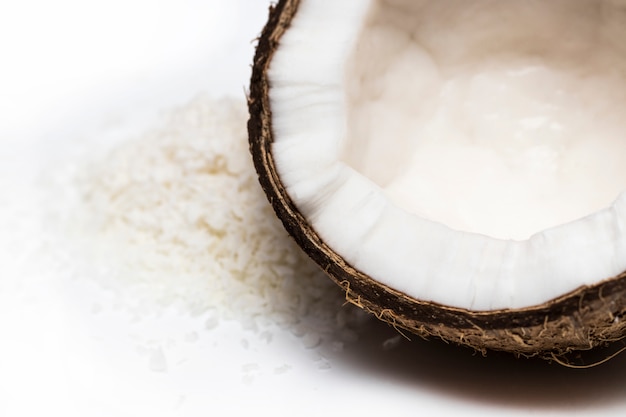 Noix de coco avec des flocons de noix de coco isolés sur fond blanc