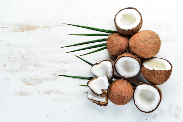 Noix de coco fraîche sur fond de bois blanc Vue de dessus de noix de fruits tropicaux Espace libre pour votre texte