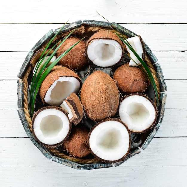 Noix de coco fraîche sur fond de bois blanc Vue de dessus de noix de fruits tropicaux Espace libre pour votre texte