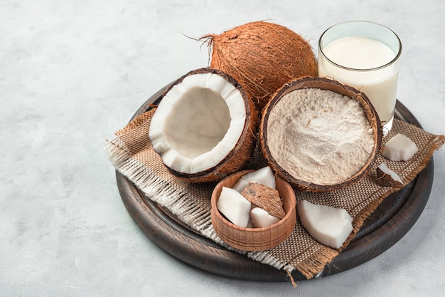 Noix de coco fraîche et produits de noix de coco sur fond gris. Farine de coco et lait de coco.